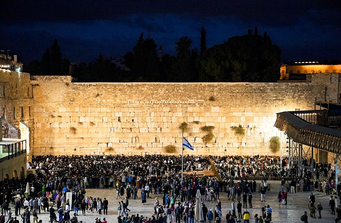 People praying at the Western Wall at night