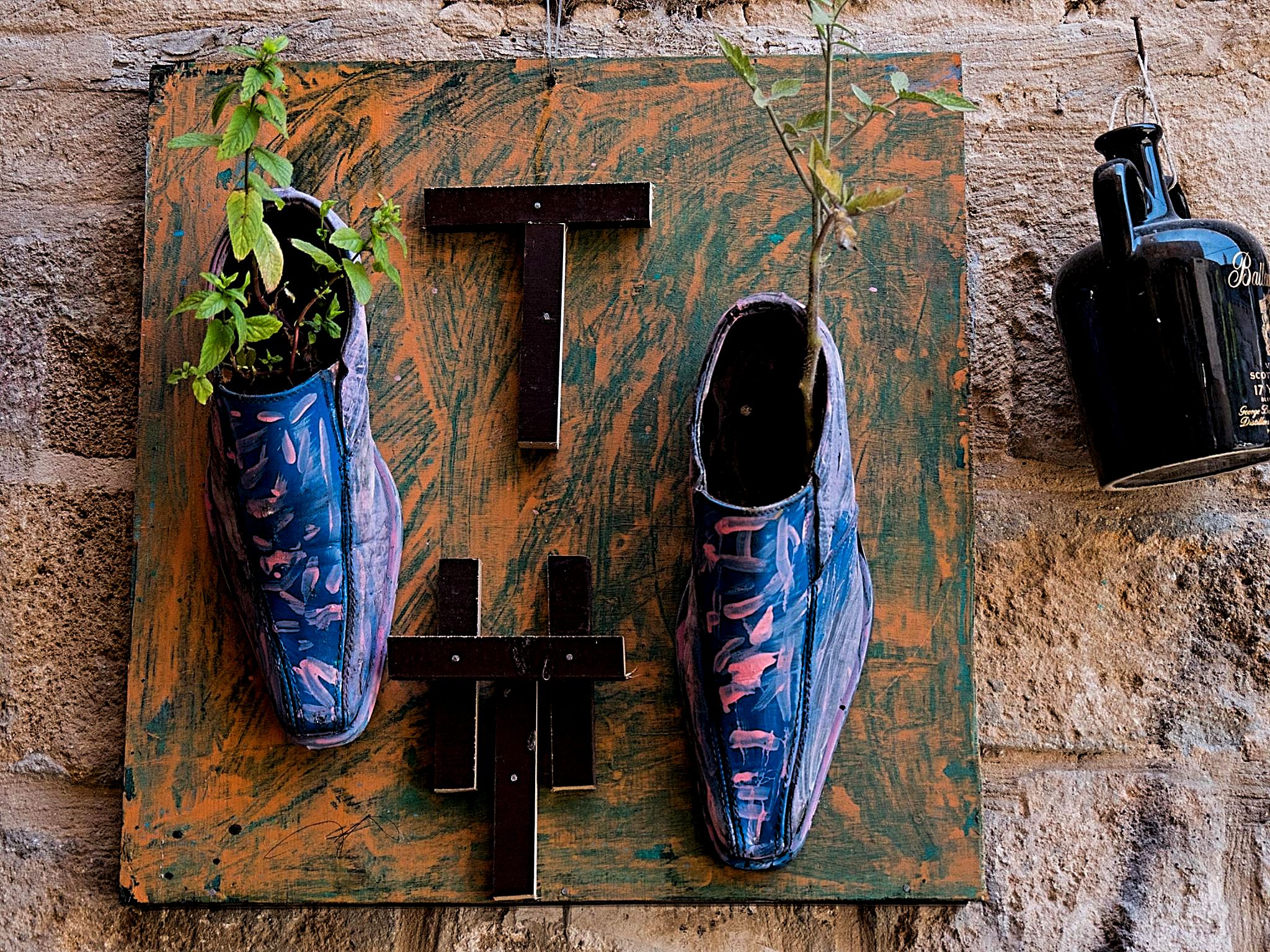 Men's shoes on the wall of a house in Acre, Israel