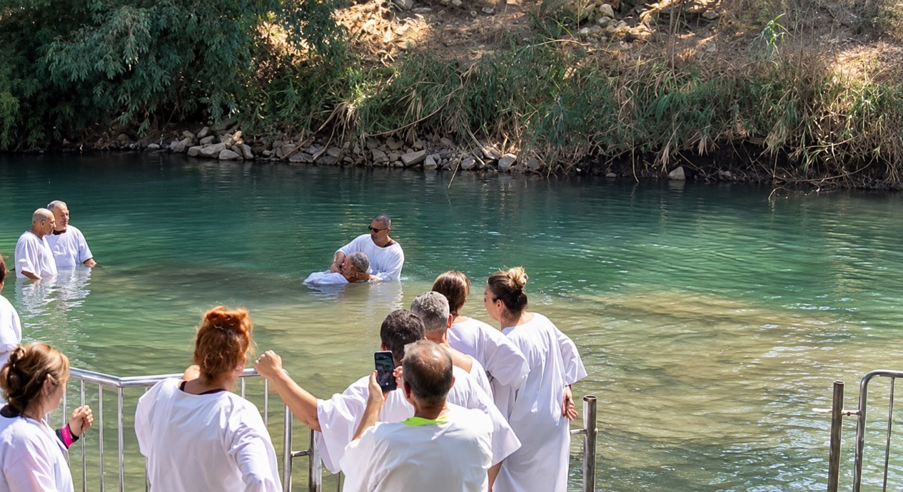 Holy Land Pilgrimage for Christian Families - Pilgrims being baptized in the Jordan River.