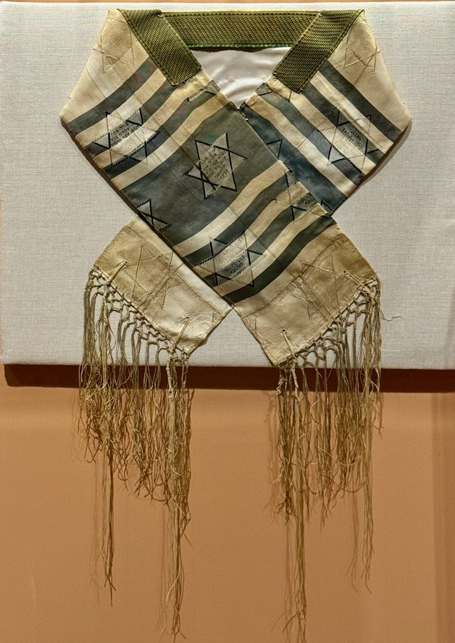 Tallit (Jewish prayer shawl) A tallit with stripes and fringes. The Jewish prayer shawl inspired the flag’s design.