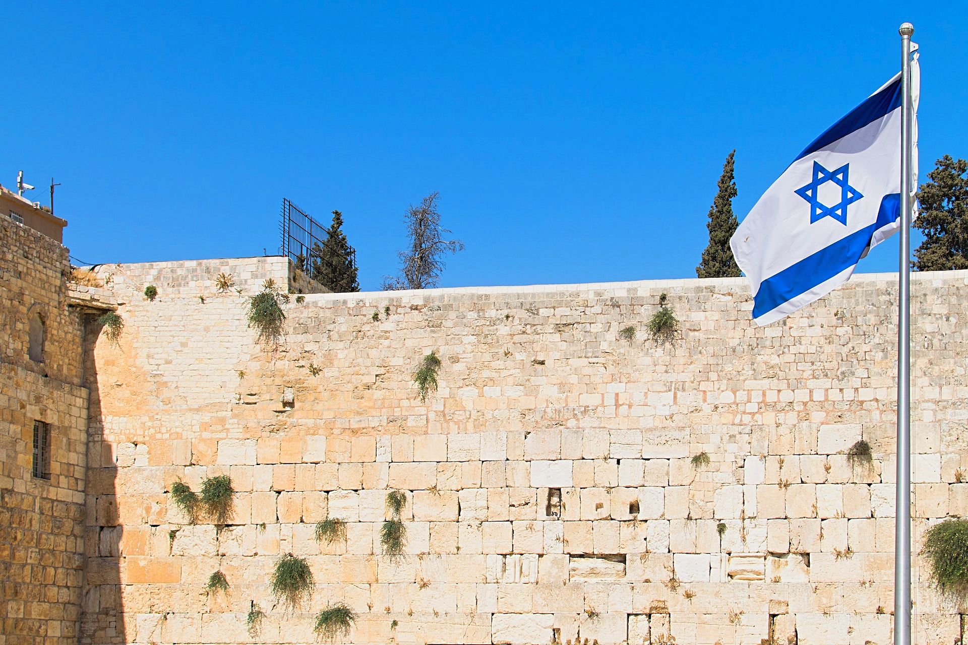 The Western Wall in Jerusalem with an Israeli flag in the foreground