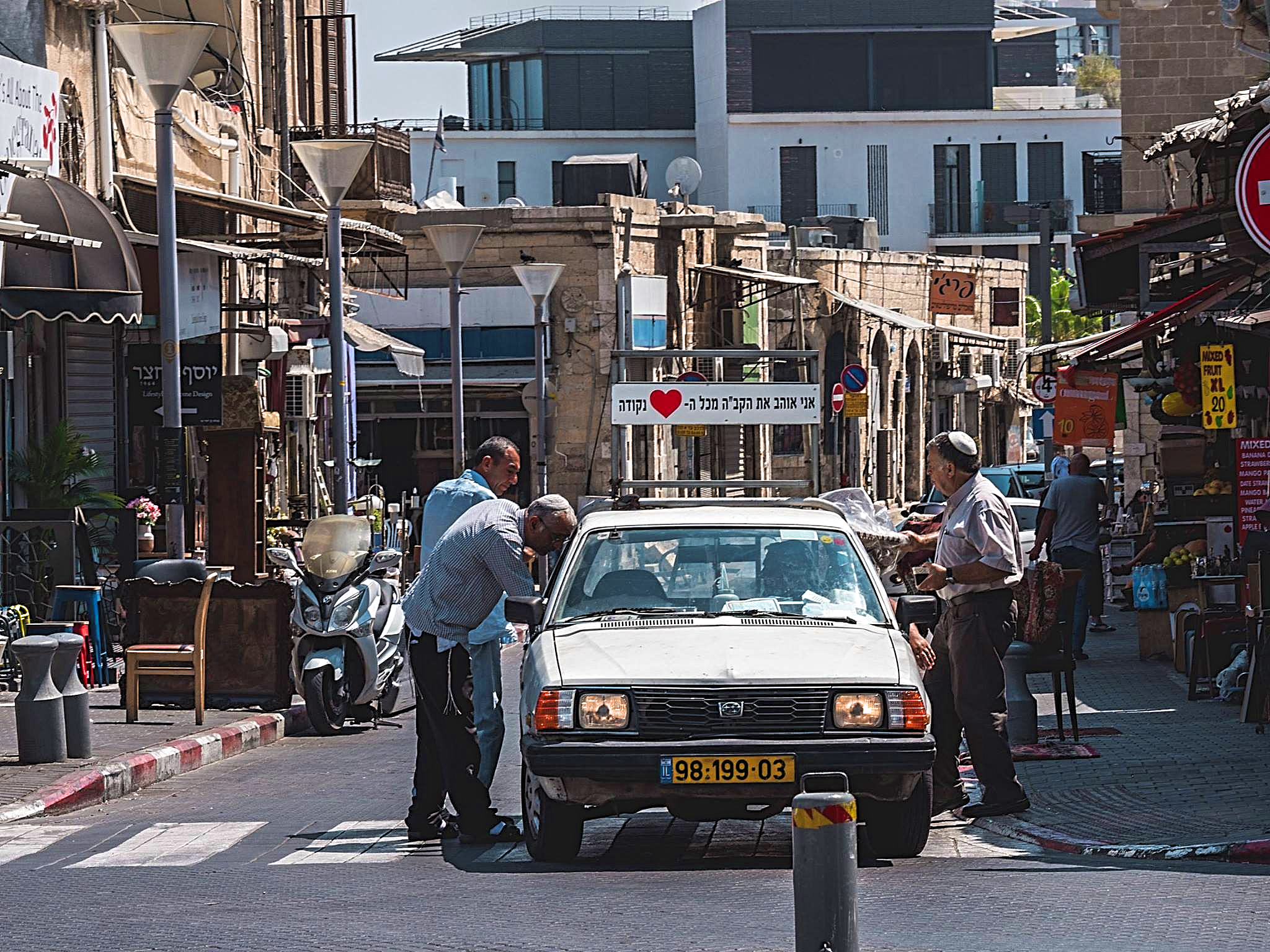  A car driver chatting with his pals in the middle of the street, Jaffa, Israel
