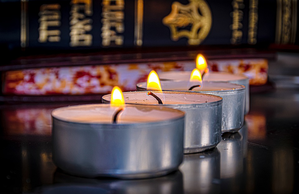 Yahrzeit  (memorial) candles against the background of a Torah