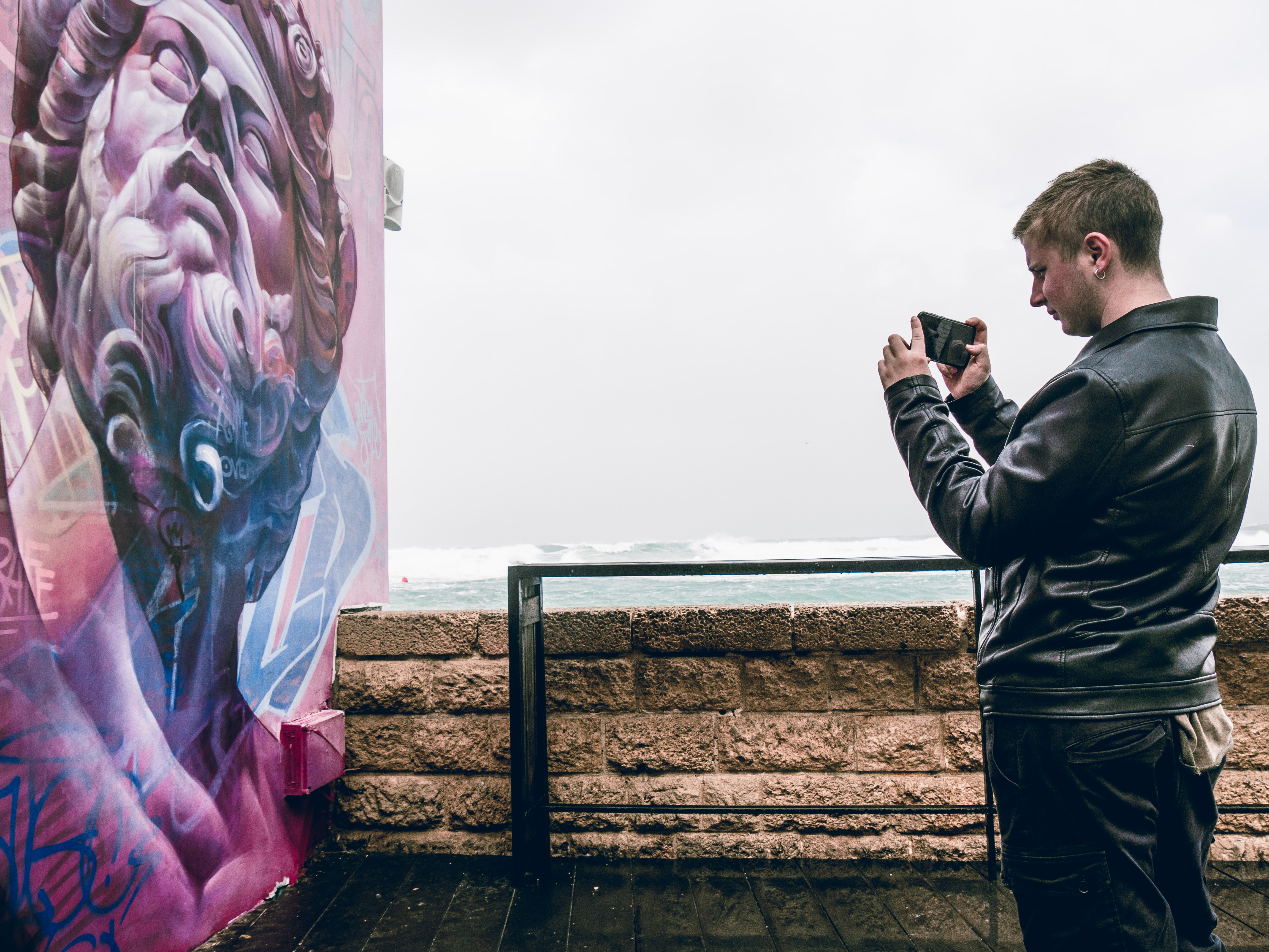 A tourist taking a picture of Tel Aviv graffiti