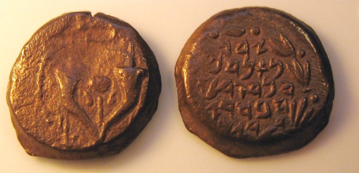 Both sides of a bronze prutah of Alexander Jannaeus: an ancient Hebrew inscription and double cornucopias with a pomegranate. This illustrates the ruler’s coinage, not the widow’s actual coins.